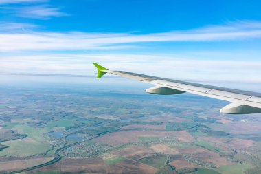 Moskova, Rusya 'ya iniş sırasında uçak kanadı, mavi gökyüzü ve kara manzarası. Uçak penceresi manzaralı. Dünya ve gökyüzü bir uçağın penceresinden görüldüğü gibi.
