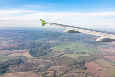 Moskova, Rusya 'ya iniş sırasında uçak kanadı, mavi gökyüzü ve kara manzarası. Uçak penceresi manzaralı. Dünya ve gökyüzü bir uçağın penceresinden görüldüğü gibi.