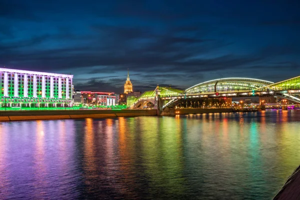 Moskova Nehri 'ni yansıtan renkli Bogdan Khmelnitsky köprüsünün görüntüsü. Moskova Kiyevsky tren istasyonu, gece. Moskva Nehri üzerindeki yaya köprüsü. Moskova, Rusya