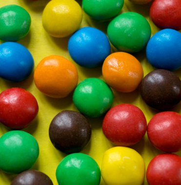 Sarı arkaplanda çok renkli şekerler