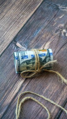 100 dolarlık banknotlar. Dolarlar halatla bağlanmış karanlık bir arka planda
