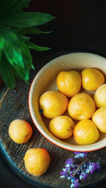 Koyu arkaplanda sarı kayısılar.