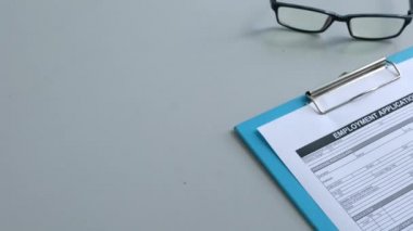 İş başvurusunda bulunan kişi iş başvurusu formunu bir kalemle doldurmak üzere.