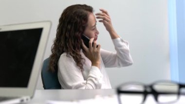 İş kadını dinliyor ve telefonda konuşuyor. Ofis ayarları.