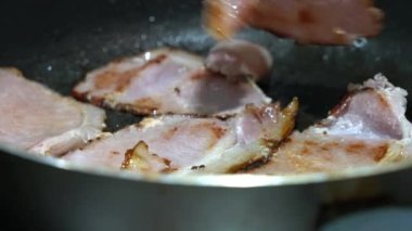 Fesleğenli bir tavada domuz pastırması pişirmek. Kızarma. Yağlı. Servis edilmeye hazır.