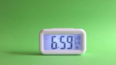Dijital saat, saat 6: 59 'dan 7' ye kadar değişiyor. Alarm saati ya da uyuyakalmış konsept.
