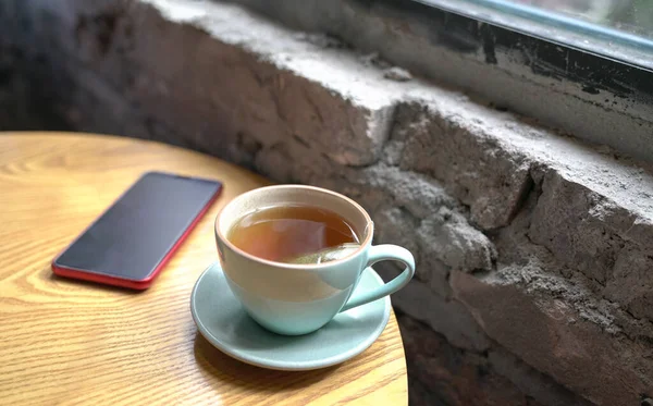 Xícara Chá Quente Celular Mesa Madeira Lado Das Janelas — Fotografia de Stock