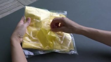 Yeni poşetlerden yeni poşetler çıkaran bir kadın. Yakın çekim. Günlük plastik tüketim kavramı.