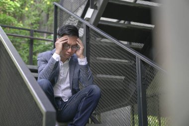 Stresli iş adamı merdivenlerde oturuyor. İş krizi veya iş stresi kavramı.