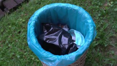 Kullanılmış plastik poşeti çöpe atan kadın. Yakın çekim. Plastik kirliliği veya iklim değişikliği kavramı.