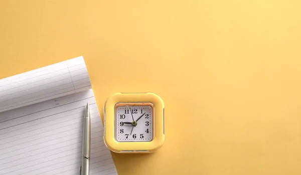 黄色的钟和写笔记垫在黄色的桌子顶部 复制空间 — 图库照片