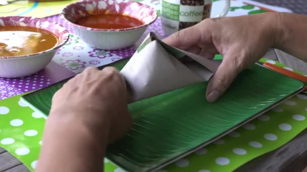 冷たいココナッツミルクで調理されたナシレムクやマレーシアの香り米のパッケージから食べる人 — ストック動画