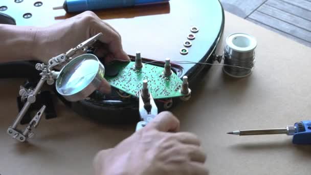 Hombre Reparar Placa Circuito Guitarra Atornillar Una Tuerca Con Alicate — Vídeo de stock