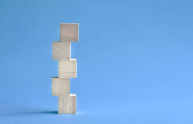 5 harfli boş ve tahta blok üst üste yığılmış. Mavi arka planda. Boşluğu kopyala.