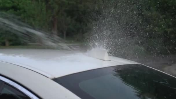 洗车时 从高压喷射冲洗软管喷出的水淋淋在一辆白色的车上 早上洗车 慢动作 — 图库视频影像