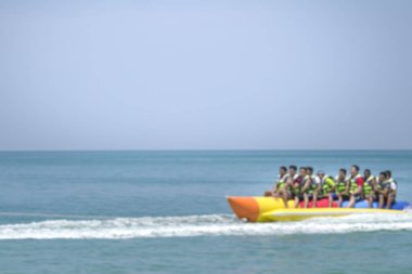 Denizde muz teknesinde bir grup insan. Dikkati dağılmış. Yaz tatili geçmişi.