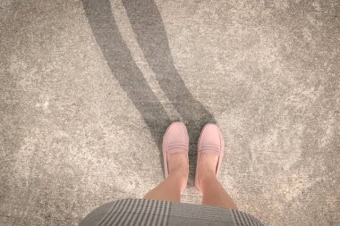 Sokakta gölgeli pembe ayakkabılar giyen bir kadın. Boşluğu kopyala.