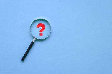 Büyüteç ve mavi arka planda kırmızı soru işareti. Boşluğu kopyala, üst görünüm.