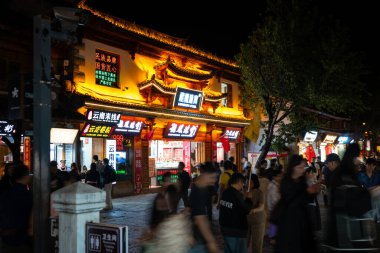 Dali, Çin - 10 Ekim 2025: Geleneksel mimari, mağazalar, restoranlar ve çok sayıda turistle Dali Antik Kentinde sokak manzarası.