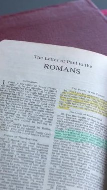 Yeni Ahit 'in Romalılar Kitabı, Kutsal İncil. Yazılı form, Yeni Standart Versiyon. Yüksek açı, dikey video.