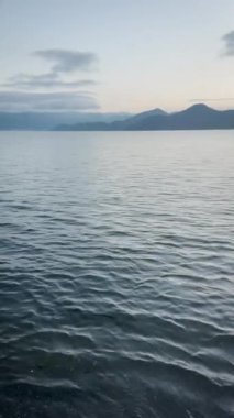 Şafak vakti göl suyu. Çin, Yunnan 'daki Lugu Gölü. Dikey video