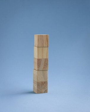 Mavi arka planda beş boş tahta blok üst üste yığılmış..