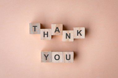 Kare tahta bloklarda, şeftali arkaplanda izole edilmiş sözlere teşekkür ederim..