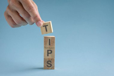 Kelimenin tam anlamıyla tahta blokları diziyorum, Tips. Açık mavi yüzeyde izole edilmiş..