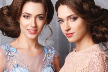 Yakın çekim portre lüks güzel ikiz genç kadınların elbise, pastel renkler. Güzellik moda portre