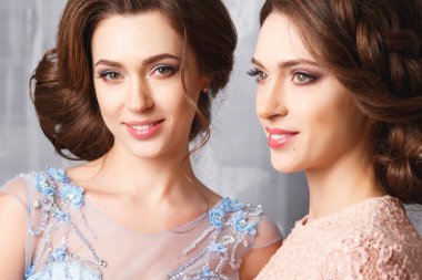 Yakın çekim portre lüks güzel ikiz genç kadınların elbise, pastel renkler. Güzellik moda portre