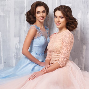 İki güzel ikiz genç bayan lüks elbise, pastel renkler. Güzellik moda portre