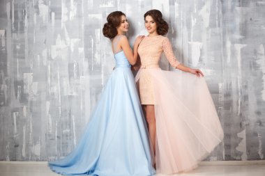 İki güzel ikiz genç bayan lüks elbise, pastel renkler. Güzellik moda portre