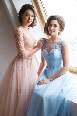İki güzel ikiz genç bayan lüks elbise, pastel renkler. Güzellik moda portre
