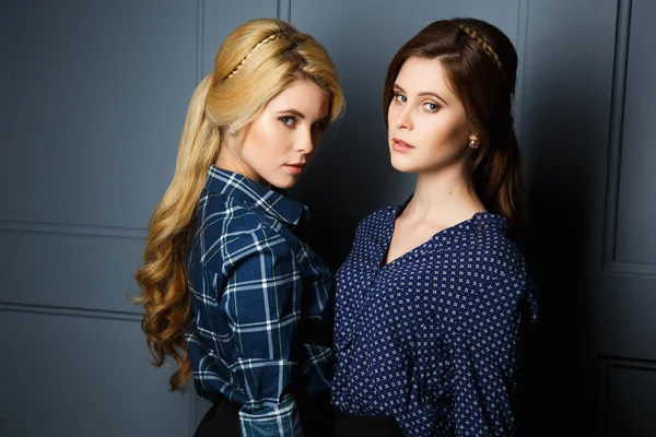 Schöne junge Zwillinge Frauen in einem Hemd und Röcken und perfekte Make-up und Frisur — Stockfoto