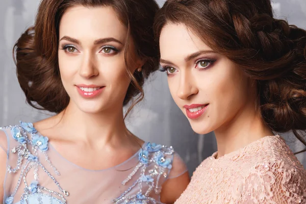 Крупный план портрета красивых близнецов молодых женщин в роскошных платьях, пастельных тонах. Портрет красавицы — стоковое фото