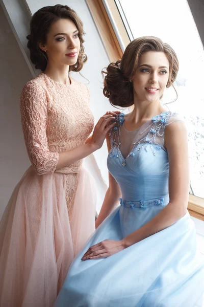 Deux belles jumelles jeunes femmes en robes de luxe, couleurs pastel. Beauté portrait de mode — Photo