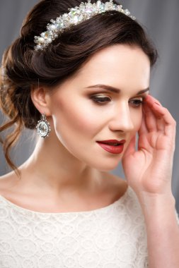 Beyaz bir elbise mükemmel makyaj ve saç stili ile zarif genç kadın. Aksesuarları ile güzellik moda portre