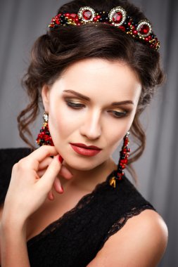 Mükemmel makyaj ve saç stili diadem ve küpeler ile siyah elbiseli olan zarif kadın. Güzellik moda portre aksesuarları ile