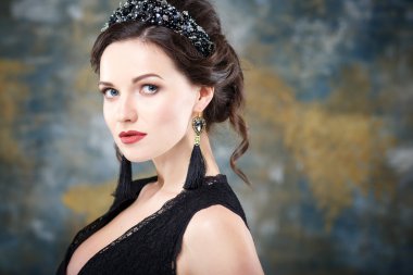 Mükemmel makyaj ve saç stili diadem ve küpeler ile siyah elbiseli olan zarif kadın. Güzellik moda portre aksesuarları ile