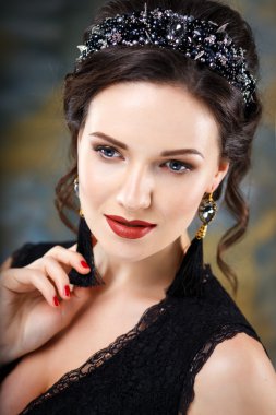 Mükemmel makyaj ve saç stili diadem ve küpeler ile siyah elbiseli olan zarif kadın. Güzellik moda portre aksesuarları ile