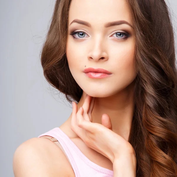 Retrato de cerca de una hermosa mujer joven con hermoso cabello y maquillaje natural. Moda belleza foto — Foto de Stock