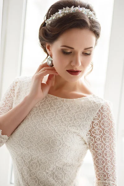 Elegante mujer joven con maquillaje perfecto y peinado en un vestido blanco. Retrato de moda de belleza con accesorios — Foto de Stock