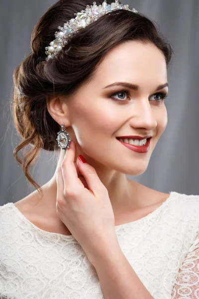 Элегантная молодая женщина с идеальным макияжем и прической в белом платье. Портрет красоты с аксессуарами — стоковое фото