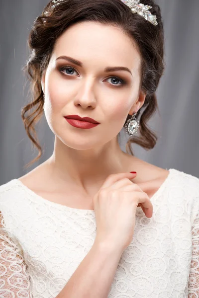 Jovem elegante com maquiagem perfeita e estilo de cabelo em um vestido branco. Retrato de moda de beleza com acessórios — Fotografia de Stock