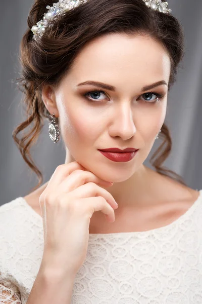 Jovem elegante com maquiagem perfeita e estilo de cabelo em um vestido branco. Retrato de moda de beleza com acessórios — Fotografia de Stock