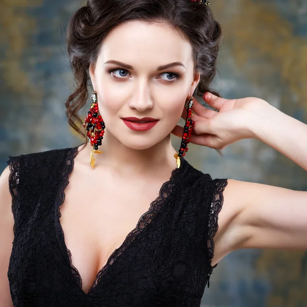 Elegante junge Frau mit perfektem Make-up und perfekter Frisur in einem schwarzen Kleid mit Diadem und Ohrringen. Beauty Fashion Portrait mit Accessoires — Stockfoto