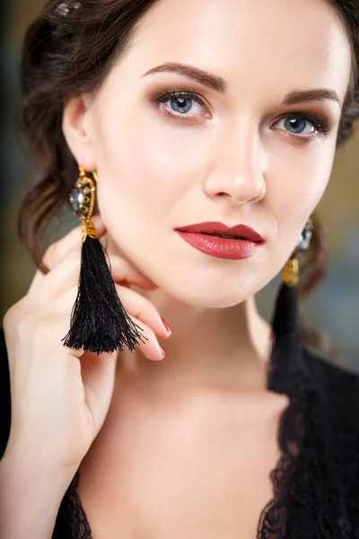 Elegante jongedame met perfecte make-up en haarkleur stijl in een zwarte jurk met diadeem en oorbellen. Schoonheid mode portret met accessoires — Stockfoto