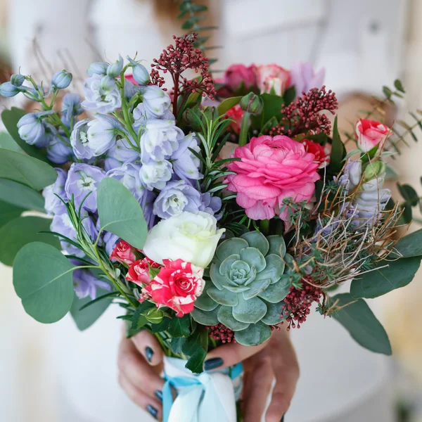 Jeune femme tient un bouquet qu'elle a fait. Décor et composition florale sur une table . — Photo