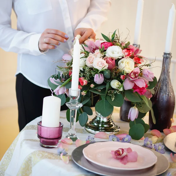 Jonge vrouw maken een decoratie. Decor en de samenstelling van de bloemen op een tafel. — Stockfoto