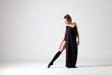 Siyah elbiseli dans eden kadın. Beyaz bir arka plan izole çağdaş modern dans. Fitness, germe modeli